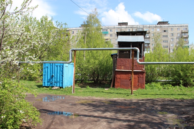Металлический контейнер, голубятня и трубы теплотрассы на металлических опорах на внутридворовой территории напротив проезда между домами № 17 и № 19 по ул. Героя Давыдова. Вид с запада
